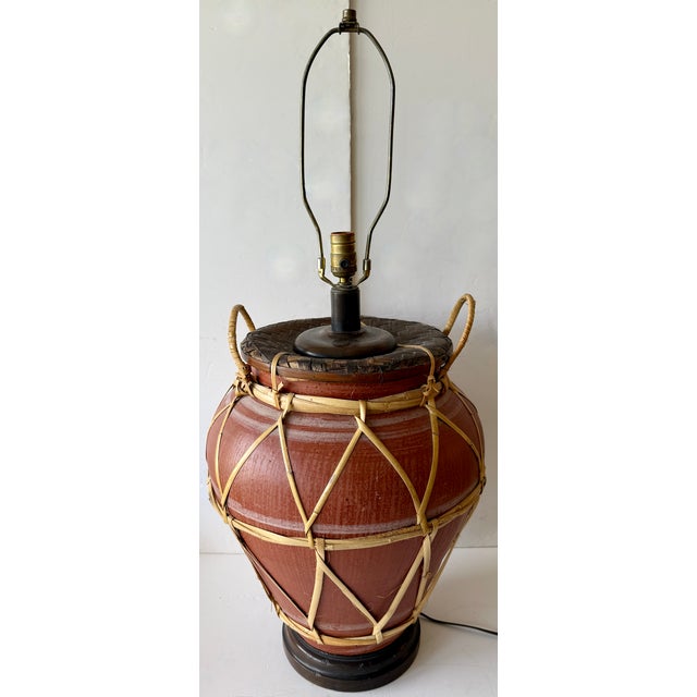 Interesting, oversize table lamp from 70's. Dark brown wooden base with terracotta body and top in woven rattan. Rattan...