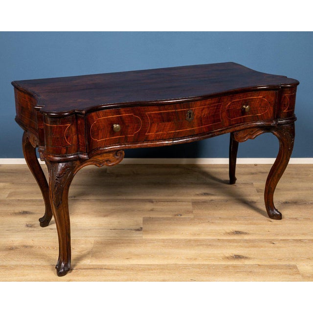 A refined Emilian-Ferrarese console table from the Louis XV period, made in the 18th century from fine walnut burl. The...