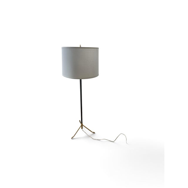 Polished brass tripod base featuring a unique, organic, claw-like foot structure. • Stem: Dark brown stitched leather-...