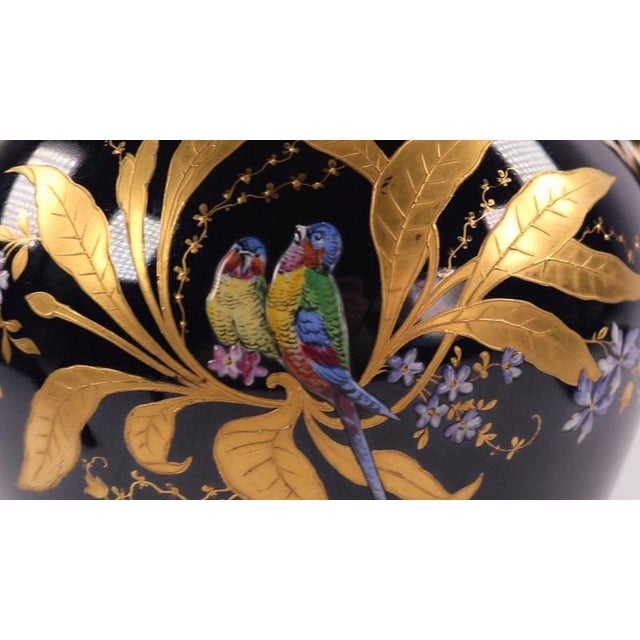 Twin scroll handles flank a rounded, swelling baluster body finished in a rich, high-gloss cobalt blue glaze. The...