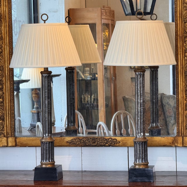 Pair of table lamps formed as fluted metal columns with alternating bronze and silvered finishes, set on square black...