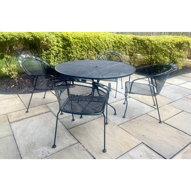 MCM cast iron mesh round table grapevine motif and 4 chairs. Woodard replica. Each chair has rounded backrest and...