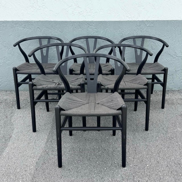 A striking set of six wishbone-style dining chairs inspired by the iconic Danish modern design of Hans Wegner. Each chair...