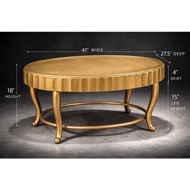Vintage Hollywood Regency oval coffee table by Decca featuring a fluted apron, graceful curved legs, and an elegant...