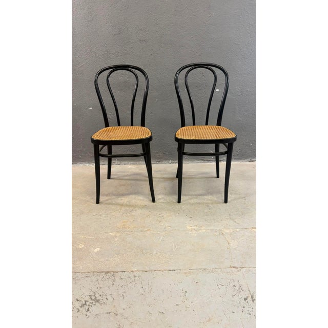 Pair of bentwood chairs with black lacquered beech frames and Vienna straw seats, produced at a former Thonet factory in...
