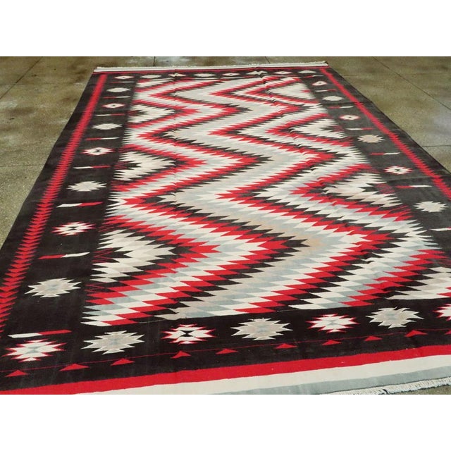 A vintage Indian Flat-weave Dhurrie carpet. A totally bold horizontal serrated zig-zag in red, black and ecru in the...