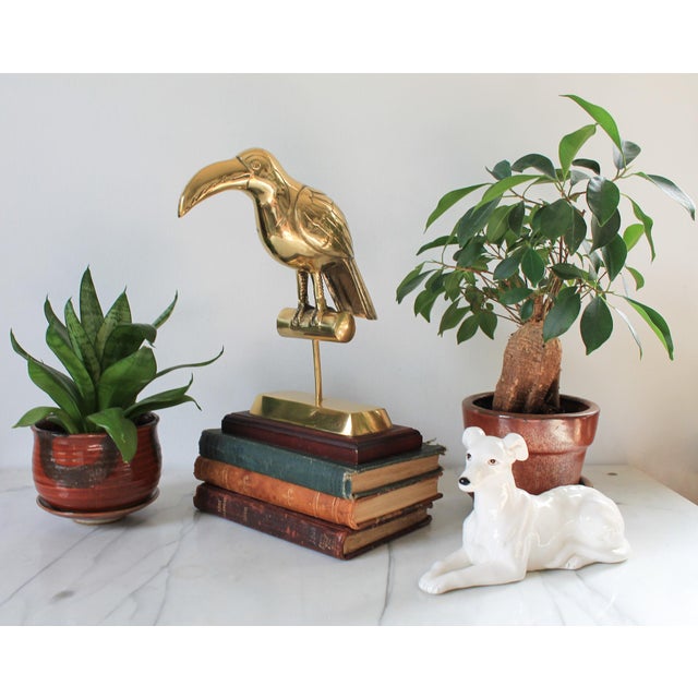 Vintage brass Tucan bird sculpture mounted on a brown wood base. Made in Korea. Minor age wear.