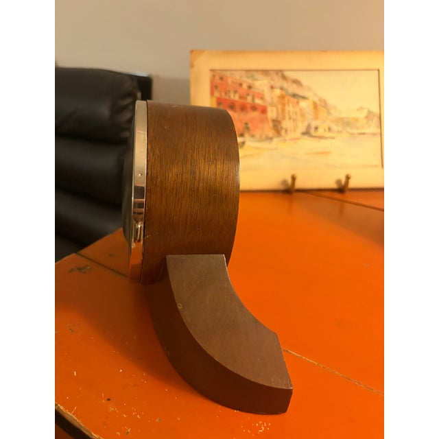 Vintage Seth Thomas mantel clock featuring a curved wooden case and a silver tone dial with Roman numerals. This clock has...