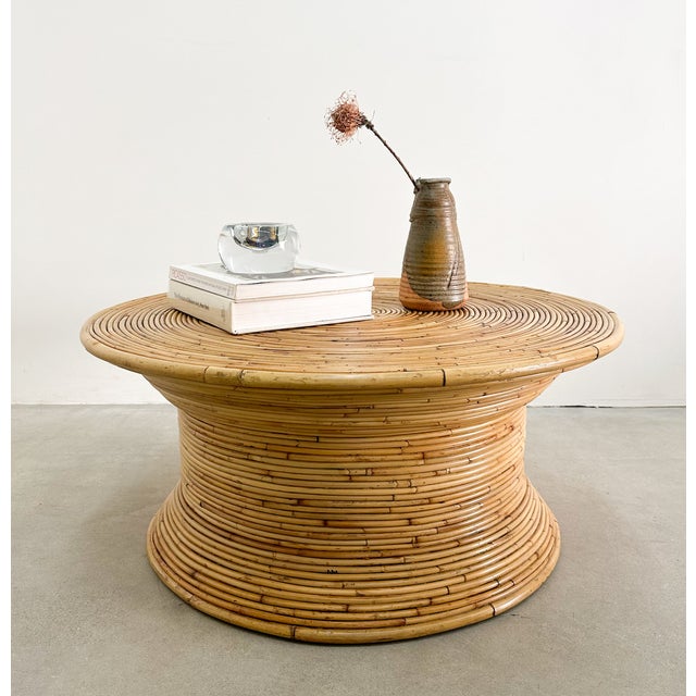 Vintage split-reed rattan coffee table featuring a hand-wrapped concentric spiral design. The sculptural spool form and...