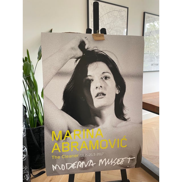 Exhibition poster featuring Art Must Be Beautiful, Artist Must Be Beautiful (1975) by Marina Abramović, one of the most...