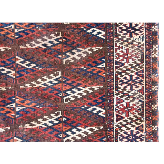 A beautiful hand-woven antique Persian Yamut rug dating to circa 1920. Crafted from high-quality wool colored with natural...