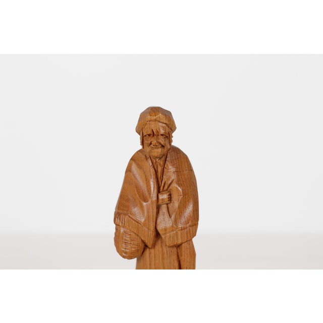 Vintage hand-carved wooden folk figure of a Quebec elderly woman carrying a basket. Carved from honey-toned wood with...