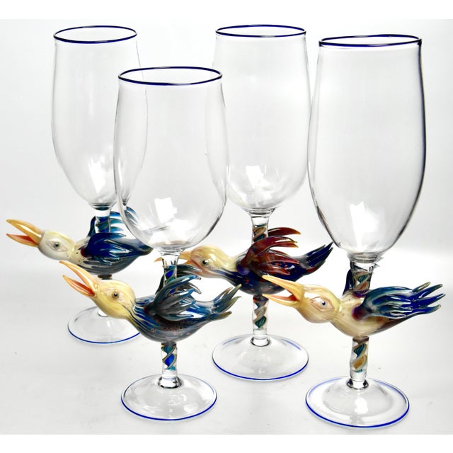 An impressive group of entirely hand blown art glass goblets, showcasing the whimsically sculptured bird forms mounted on...