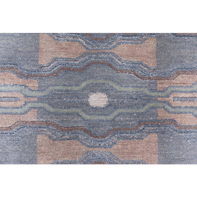 This Modern Hand-Knotted Wool Rug exudes a serene and sophisticated aesthetic through its intricate, geometric pattern and...