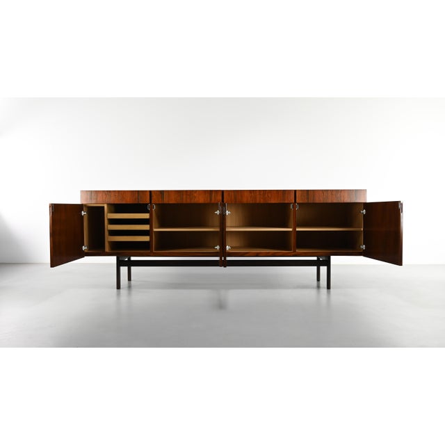 Important rosewood credenza by Danish designer Ib Kofod-Larsen. Crafted in solid rosewood and rosewood veneer, it features...