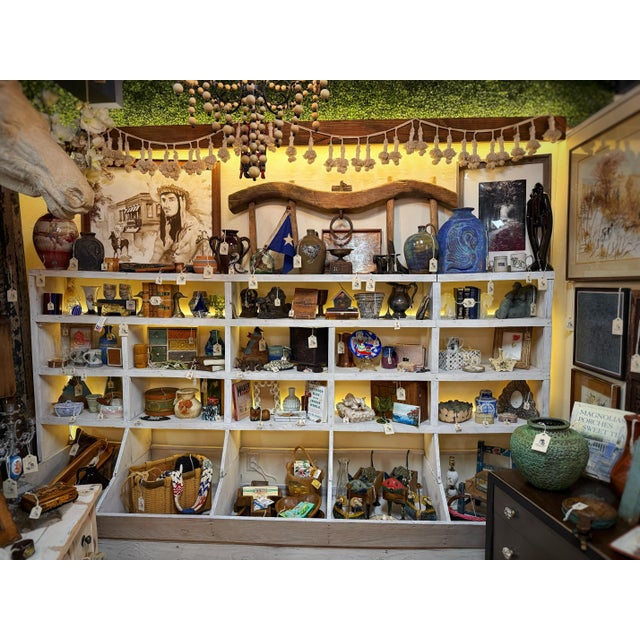 A substantial primitive wooden display cabinet originating from a general feed store, believed to date to the 1940s. With...