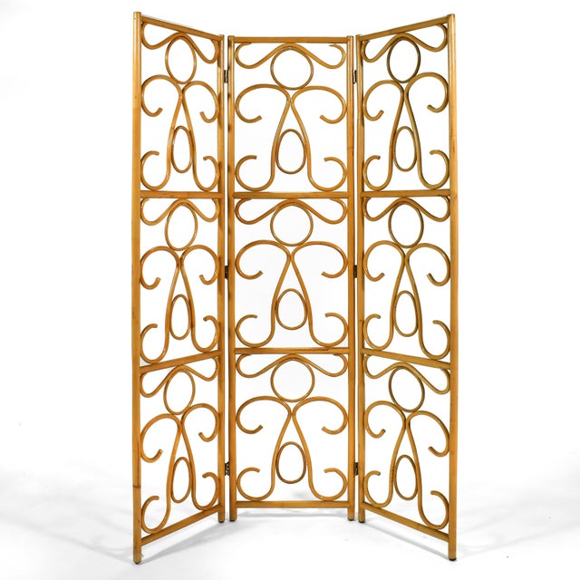 Light, airy, and elegant, this folding screen of rattan has a lovely scrollwork pattern to the three articulating panels....