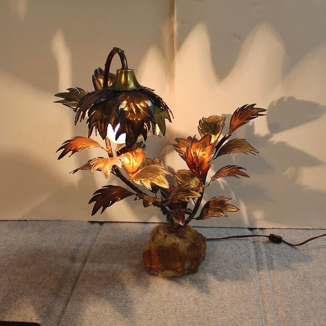 Mid-century modern accent light is a brass tree sculpture with torch-edged brass and copper leaves on a lacquered quartz...