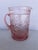 Vintage pink thick hand-blown glass water pitcher featuring a decorative molded design. Transparent pink Glass with...