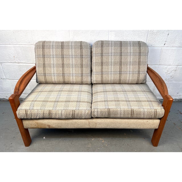 A charming mid-century Danish teak two-seat sofa featuring a sturdy, sculpted frame and classic MCM lines. The original...