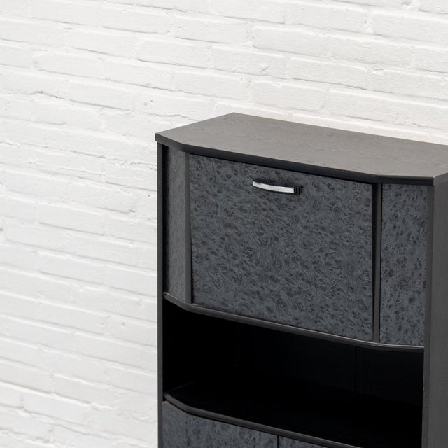 Compact postmodern bar cabinet from the 1980s, finished in black wood veneer with striking burl wood-effect panels. The...