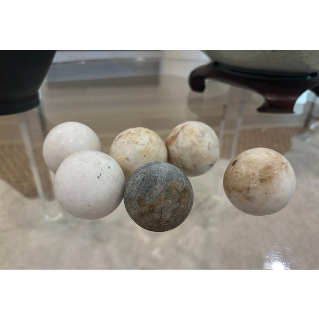 A wonderfully timeworn collection of 6 antique stone spheres, including five pale marble or limestone examples believed to...