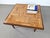 This amazing square coffee table has Wengé sides and a center of parquet shaped wooden strips and teak feet. it just...
