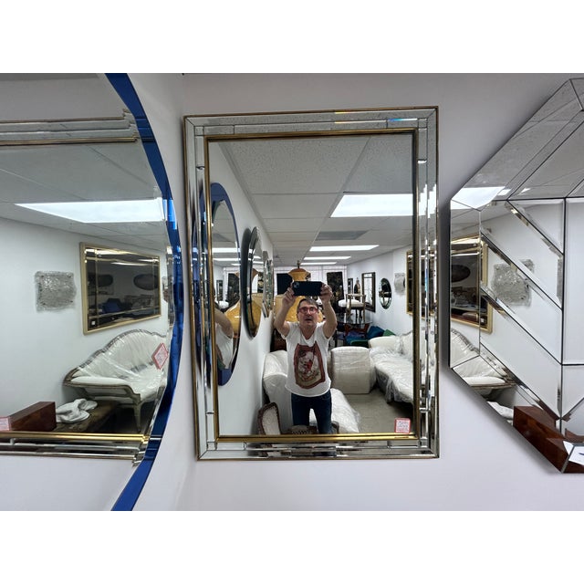 Vintage Italian Multi Beveled Mirror. This glamorous Italian Hollywood Regency mirror set in a patinated brass frame has a...