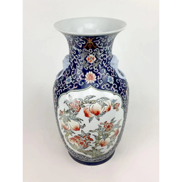 The window on this vase prominenetly features a cornucopia of peaches and blossoms. Tendrils occupy the space beyond these...