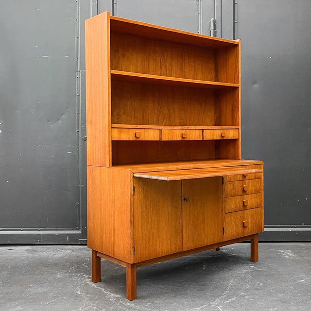 Product. Shelving unit style. Mid-century · 1960s material. Teak veneer features. Two-piece · upper section with three...