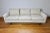 Mid-Century three seat sofa in a sandy beige and white woven upholstery similar to a boucle. Three down-filled back...