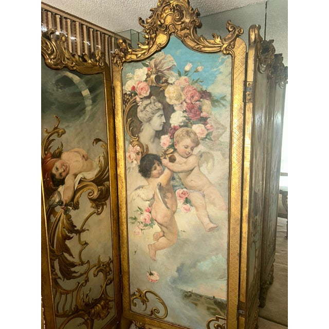 Magnificent 19th-century French Rococo-style three-panel folding screen featuring exquisite hand-painted cherubs, floral...
