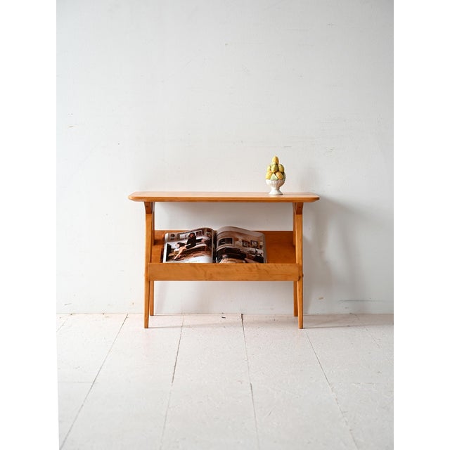 Birch coffee table with upper shelf and inclined display compartment. Lightweight structure with slender legs and refined...