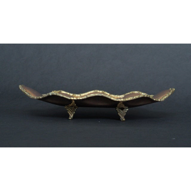 Lovely vintage midcentury handmade copper trinket dish with a ruffled design and brass trim and feet. There is a maker's...