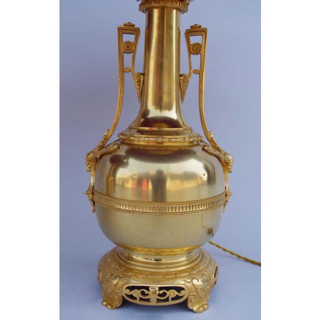 Pair of gilt brass and bronze bottle-shaped lamps with Etruscan style handles, standing on a Chinese style circular...