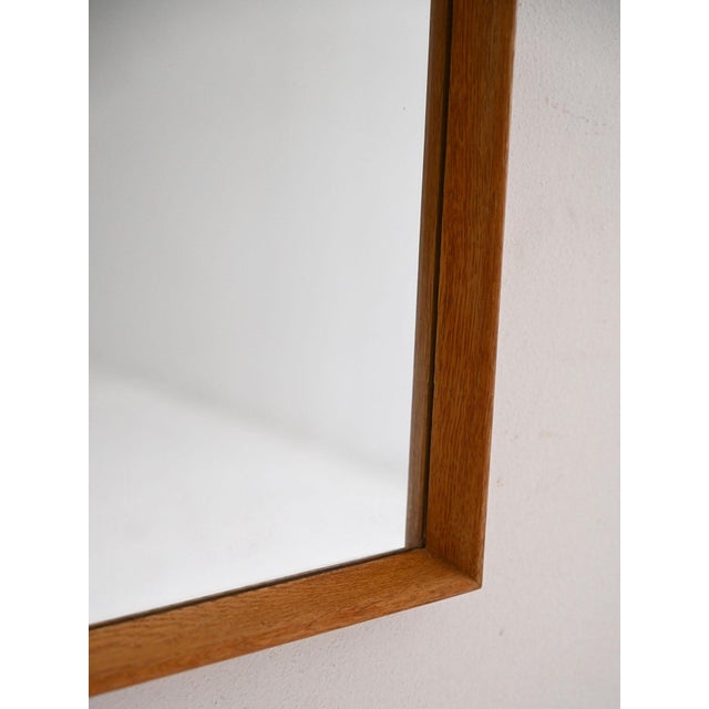 Rectangular mirror with a cantilevered oak frame, a minimalist design from the 1960s Nordic school. A Scandinavian wall...
