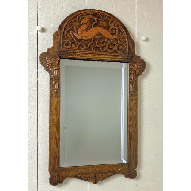 A very stylish period Art Nouveau -Art Deco mirror suggesting a jumping deer. The frame is made of oak, the fruit-carving...