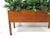 A very nice sized Mid Century teak wood indoor planter professionally potted with silk faux plants and grasses in a bed of...