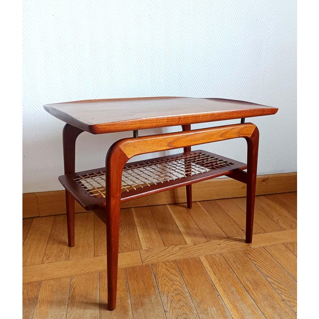 Rectangular teak coffee table resting on four legs, with a rattan stretcher in a grid pattern (refurbished). Elegant and...