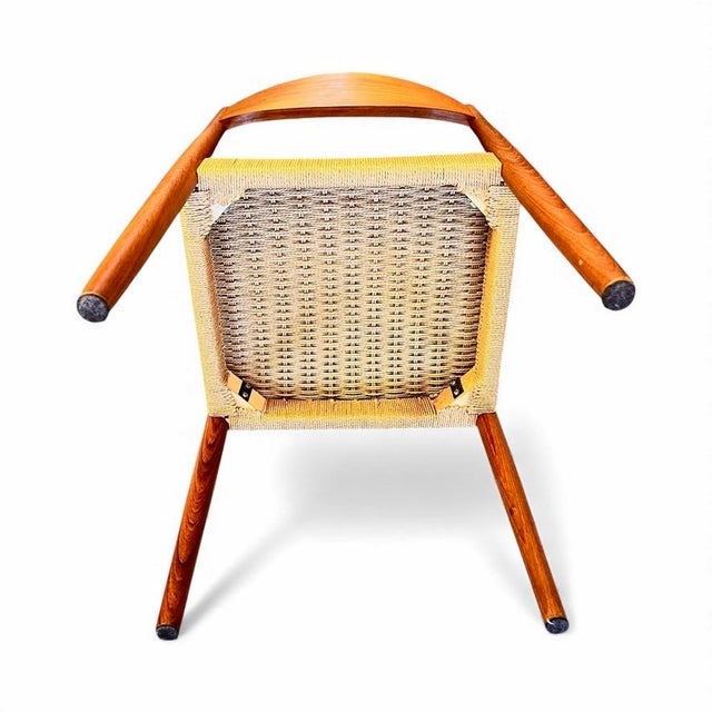 Elegant pair of mid-century modern dining chairs featuring sculpted teak-toned wood frames and beautifully executed woven...