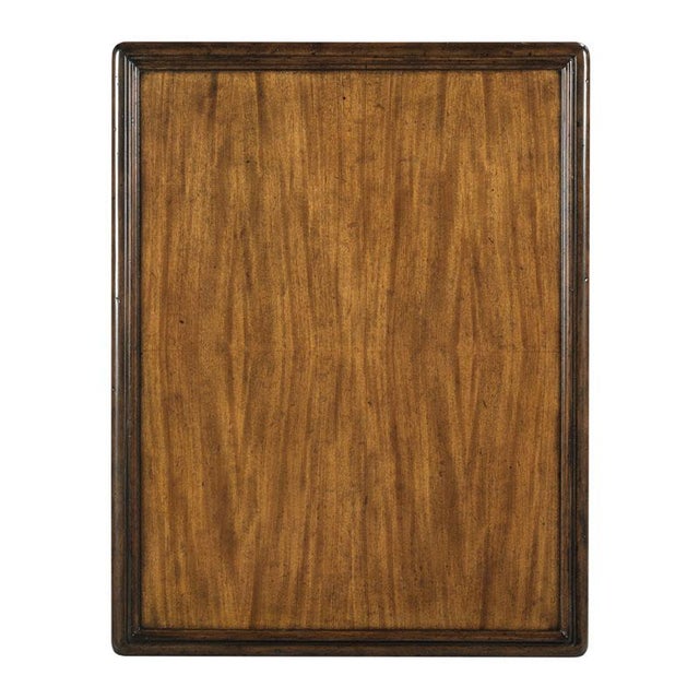 A molded rectangular top rests over four turned faux bamboo legs that are joined by a low shelf that is bound to the legs...