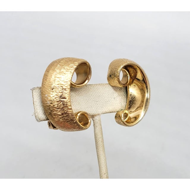 1950s goldtone curled C shaped with textured outside and smooth inside clip earrings. Marked "NAPIER PAT. PEND." Measure:...