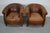 This pair of cognac-colored leather club chairs come from the Netherlands. They are upholstered with cognac-colored...