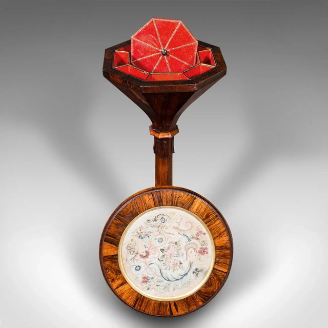 This is an antique sewing table. An English, rosewood and needlepoint tapestry crafting stand, dating to the William IV...