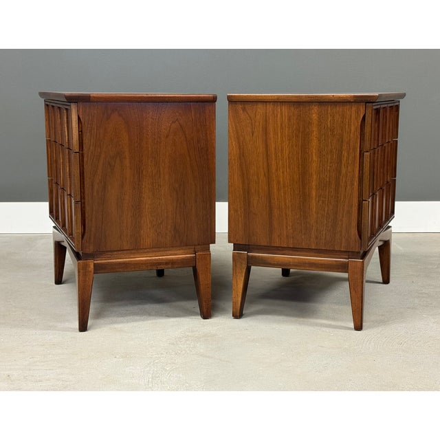 A pair of mid century modern walnut nightstands with a three dovetail drawers made by Kent Coffey Parkway. Professionally...