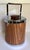 Here is a vintage Kromex ice bucket from the 1960s, featuring a classic faux woodgrain exterior with chrome lid and...