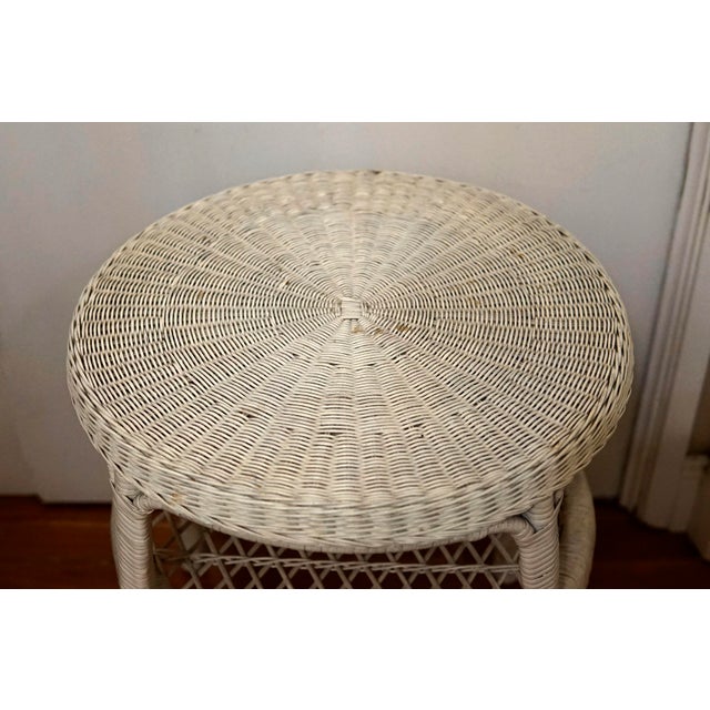 This is a wicker rattan rouncd side table and tqo tiers. The top of the table has a wood backing under the top table...