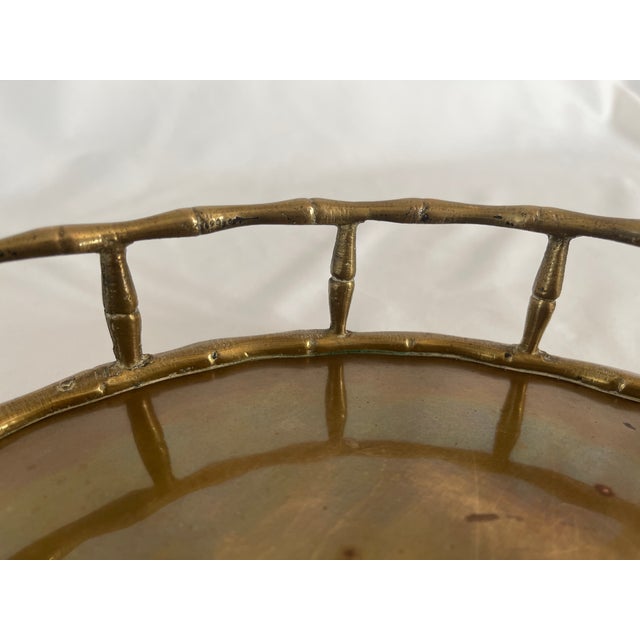 Hollywood regency style brass faux bamboo round serving tray with two handles. Aged patina to brass gives it a warm...