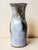 A glazed stoneware vase by Chantal and Robert Thierry, with a slender baluster shape, a narrow neck, and a wide, flared...