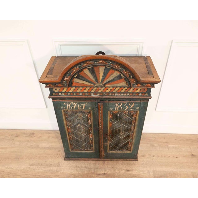 An exceptional nineteenth-century painted wall cabinet originating from the Skåne region of southern Sweden, an area...
